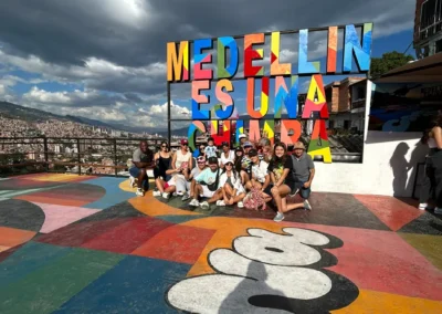 Grupo de turistas en el City Tour Medellín y Comuna 13 frente al mural “Medellín es una chimba”