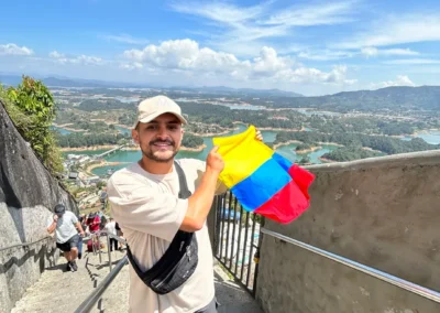 Turista con la bandera de Colombia en la cima de la Piedra del Peñol durante el tour a Guatapé