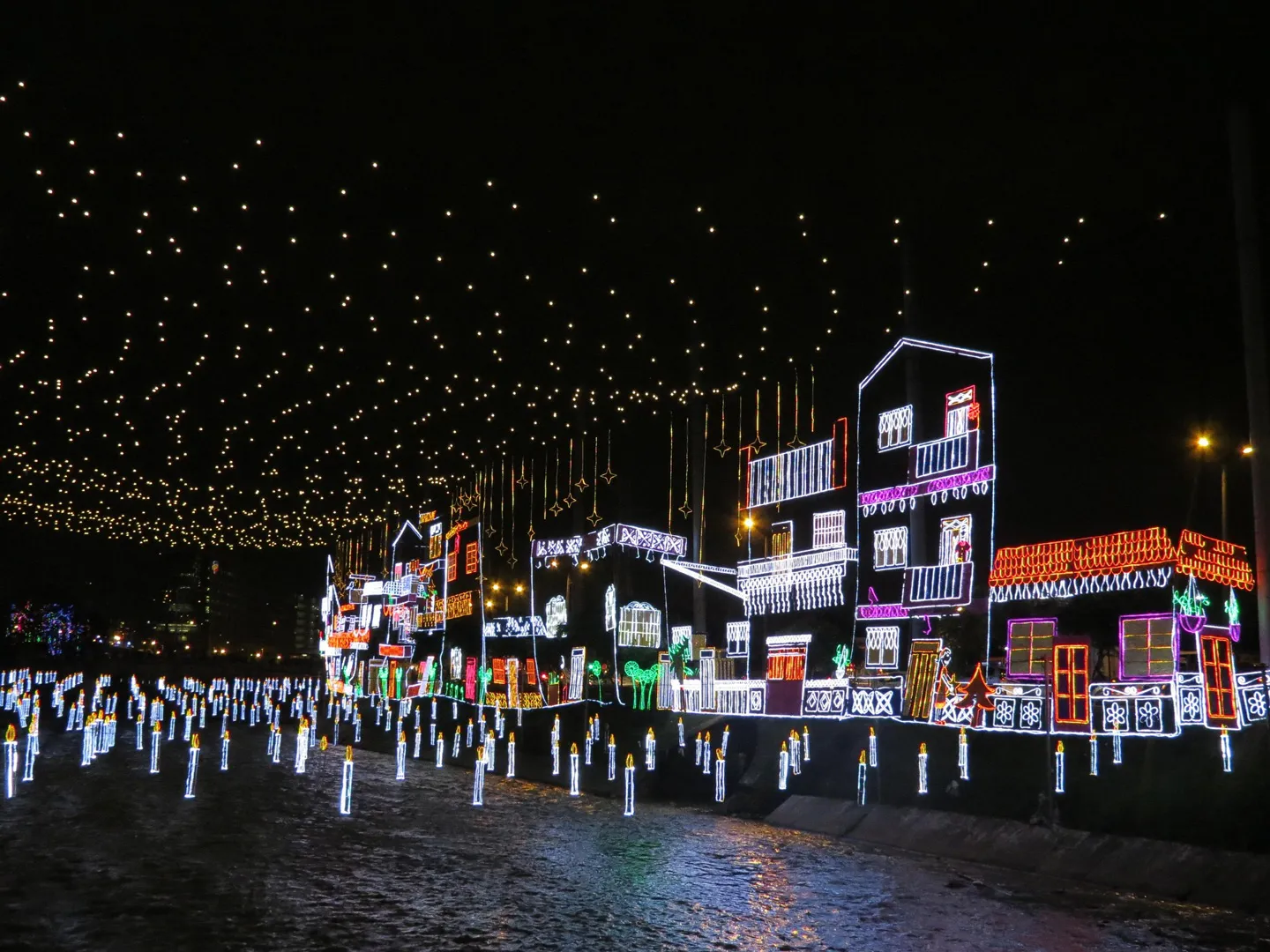 Decoraciones del Tour Alumbrados Medellín con casas iluminadas y reflejos de luces sobre el río
